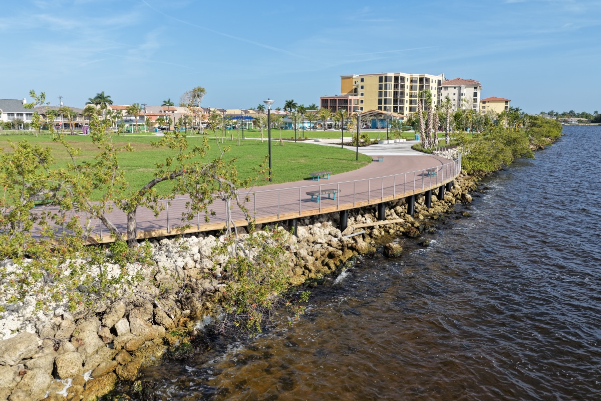 Overhead view of Jaycee Park shoreline trail, open lawn, and new trees bordering the river with nearby condos.